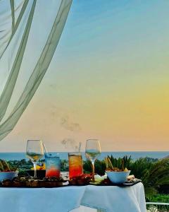阿谢亚L'incanto di Nausicaa的一张桌子和酒杯,享有海景