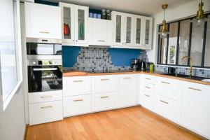 拉尼翁Résidence Le Lenn-louannec - Maisons & Villas pour 6 Personnes 784的厨房铺有木地板,配有白色橱柜。