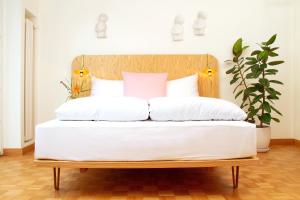 卢塞恩玛利亚别墅的一张带木制床头板和白色枕头的床