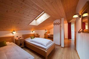 塞尔瓦迪加尔代纳山谷默克雅居酒店的一间卧室设有一张带木制天花板的大床