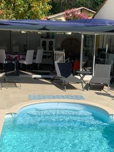 拉特斯特德布赫LA MAISON DES HIPPOCAMPES的一个带椅子和遮阳伞的游泳池