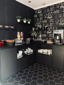 巴黎阿根诺酒店的厨房配有黑色橱柜和黑色墙壁