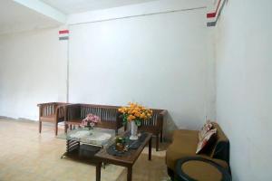 占碑市OYO 1847 Jasmine Kost Syariah的客厅配有沙发和鲜花桌