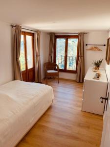 LionzaCasa Mille Sassi的卧室配有一张床、一张书桌和窗户。