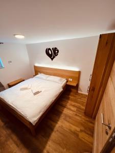 戈雷尼斯卡地区采尔克列PJagodic Hotel Cerklje - 5min to Airport的卧室配有一张带白色床单的床,墙上有心