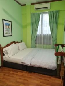 马六甲1511旅馆的一间卧室配有床和带窗帘的窗户