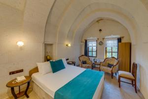 于尔居普埃尔蓬特洞穴酒店的卧室配有一张床和一张桌子及椅子