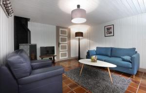 Larringes巴比伦度假屋的客厅配有蓝色的沙发和桌子