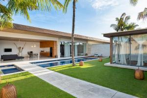 塞米亚克One Eleven的享有带游泳池和棕榈树的别墅的外部景色