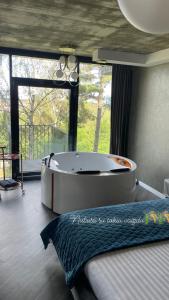 AukštkiemiaiExclusive Jacuzzi Apartaments Klaipėda的窗户客房内的大浴缸