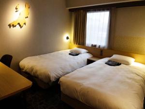 新泻HOTEL GLOBAL VIEW Niigata的酒店客房设有两张床和窗户。