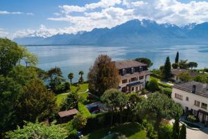 蒙特勒Montreux Rotana Garden House with Private Pool - Swiss Hotel Apartments的享有湖景和山景的度假屋的空中景致