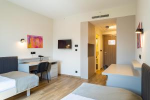 波德戈里察Hotel Verde的客房设有1张床、1张桌子和1张床。