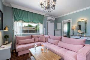阿斯格罗Cypress View Boutique Villa的客厅配有一张粉红色的沙发,配有一张桌子
