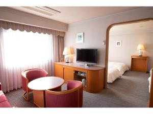 伊势市Hotel Castle Inn Ise Meotoiwa的酒店客房,配有床和电视