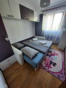 锡比乌Happy apartament的小房间,配有床和地毯
