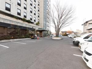 铃鹿市Hotel Castle Inn Suzuka的停车场,停车场停在大楼前
