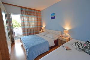 苏佩塔尔Rooms Sunce Panorama Residence, Supetar Island Brac Traveler's Choice的酒店客房设有两张床和窗户。