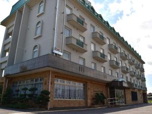 铃鹿市Hotel Castle Inn Suzuka Chuo的街道上带窗户的大型白色建筑