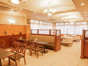 铃鹿市Hotel Castle Inn Suzuka Chuo的餐厅设有木桌、椅子和窗户。