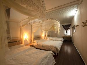 阳朔阳朔逸龙苑特色民宿的一间卧室配有两张带白色床单的床
