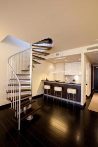 里加Hotel Bergs Suites的带螺旋楼梯的厨房和带凳子的厨房