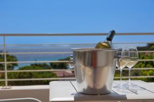 圣安蒂奥科Mercury Beach Hotel的桶装一瓶葡萄酒和两杯酒