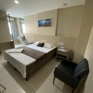 劳鲁-迪弗雷塔斯奥尼克斯机场酒店的一间卧室配有一张床和一把椅子