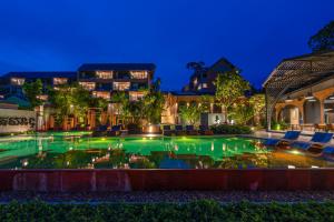拉迈Thai Fight Hotel的游泳池,后方是一座房子