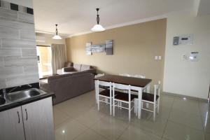 乌旺戈海滩Saints View Resort Unit 8的厨房以及带桌子和沙发的客厅。