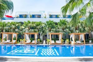 岘港Risemount Premier Resort Da Nang的酒店游泳池设有躺椅和棕榈树