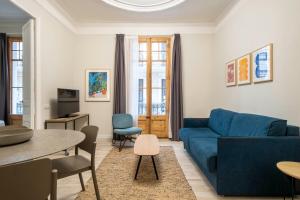巴塞罗那Aspasios Gracia Apartments的客厅配有蓝色的沙发和桌子