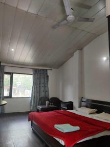 库尔卢SPOT ON Hotel Rudra的一间卧室配有一张带红色毯子的大床