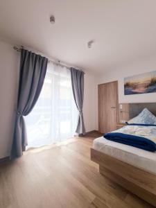 诺德代希Hotel Pension Nordzeit的一间卧室设有一张床和一个大窗户