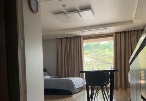 安吉利斯Luxury Condo in Clark Pampanga beside Hilton Hotel and Casino的一间卧室设有一张床、一个窗口和一张桌子