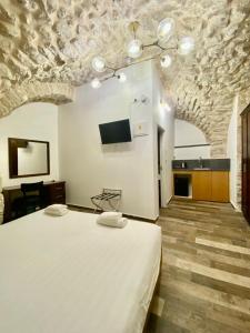 耶路撒冷Petrakis Inn的卧室配有一张白色大床和电视。
