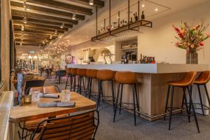 布雷达Onderwijshotel De Rooi Pannen Breda的餐厅设有带凳子的酒吧