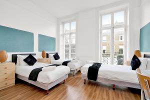 伦敦Bedford Place Hostels的一间卧室设有两张床、一把椅子和窗户。