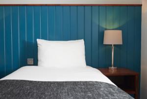 纽尼顿The Longshoot的一间卧室设有一张床和蓝色的墙壁