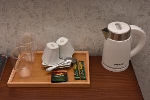 祖格迪迪Hotel & Restaurant Sokhumi的一个带咖啡壶和桌子上眼镜的托盘