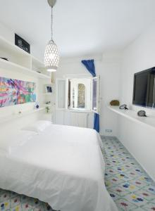 普莱伊亚诺Villa sul mare - Praiano (Amalfi Coast)的白色卧室配有白色的床和平面电视
