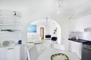 普莱伊亚诺Villa sul mare - Praiano (Amalfi Coast)的白色的厨房配有白色的桌子和椅子