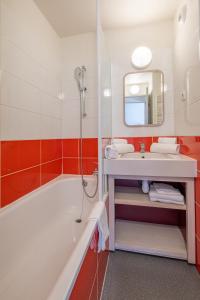 瓦勒迪泽尔拉代尔皮埃尔假日酒店的带浴缸、水槽和镜子的浴室