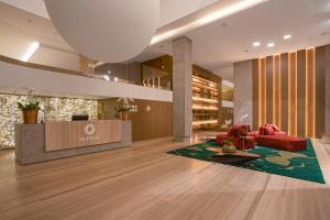 PinhaisSuryaa Hotel Pinhais, Curio Collection by Hilton的大堂设有红色的沙发和前台
