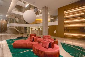 PinhaisSuryaa Hotel Pinhais, Curio Collection by Hilton的酒店大堂设有两张红色的床和楼梯