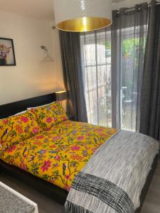 Golden ValleyA Room at The Oaks的一间卧室配有一张带五颜六色的被子的床和窗户