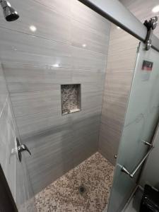 纽瓦克SPRINGVIEW HOMES 12MINS FROM EWR & 3 MINS FROM UNIVERSITY HOSPITAL的浴室里设有玻璃门淋浴