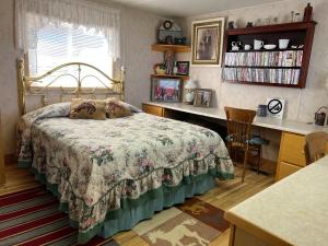 里弗顿JMA Bunkhouse的一间卧室配有一张床和一张书桌