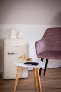 塞布尼茨ApartOne Land-Hotel的冰箱旁的桌子和椅子