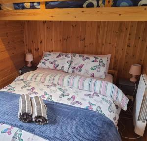 Clodockunique sheperds hut ensuite & kitchenette的一间卧室配有一张床,上面有两条毛巾